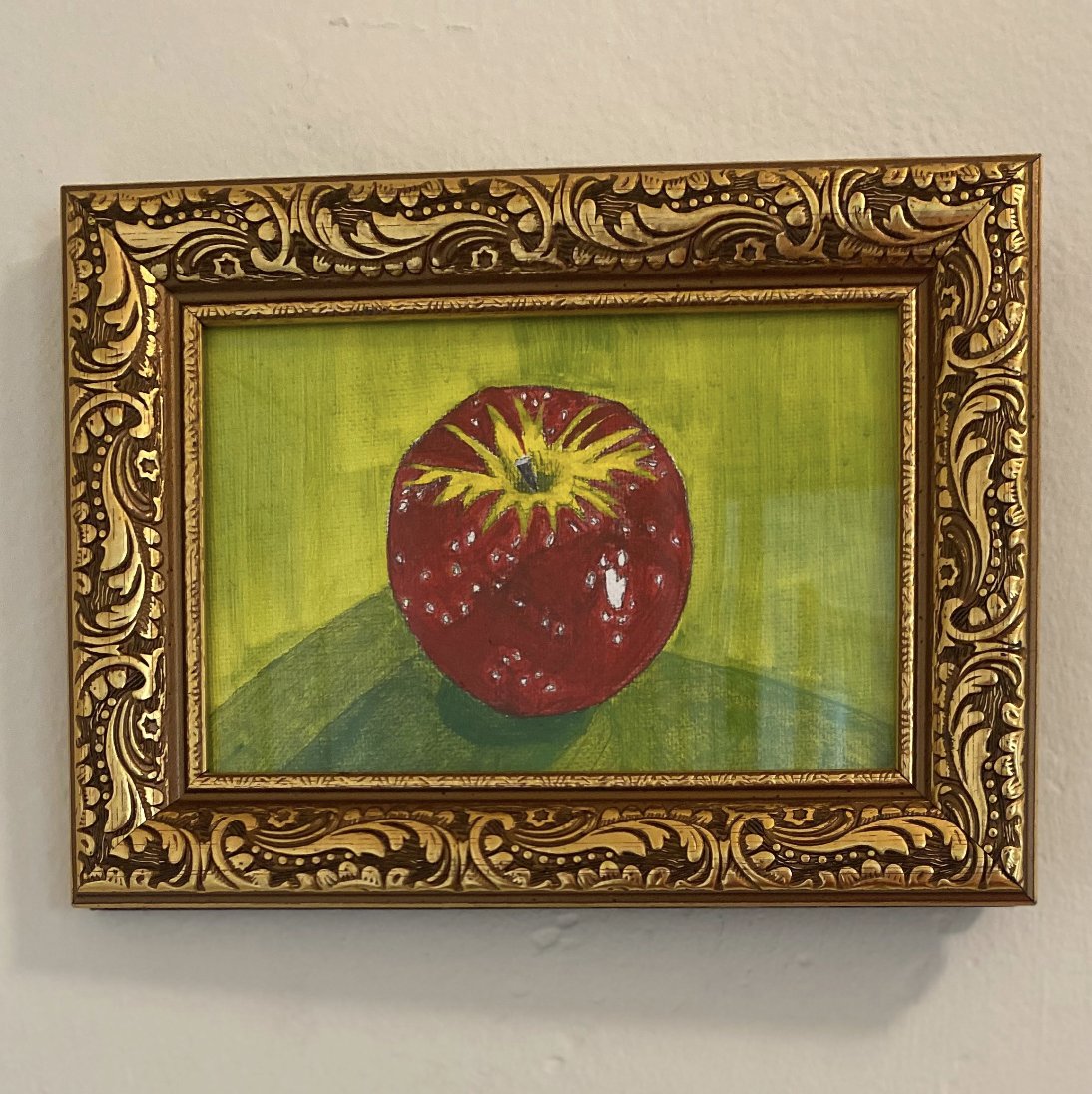 red apple with green background and a gold frame